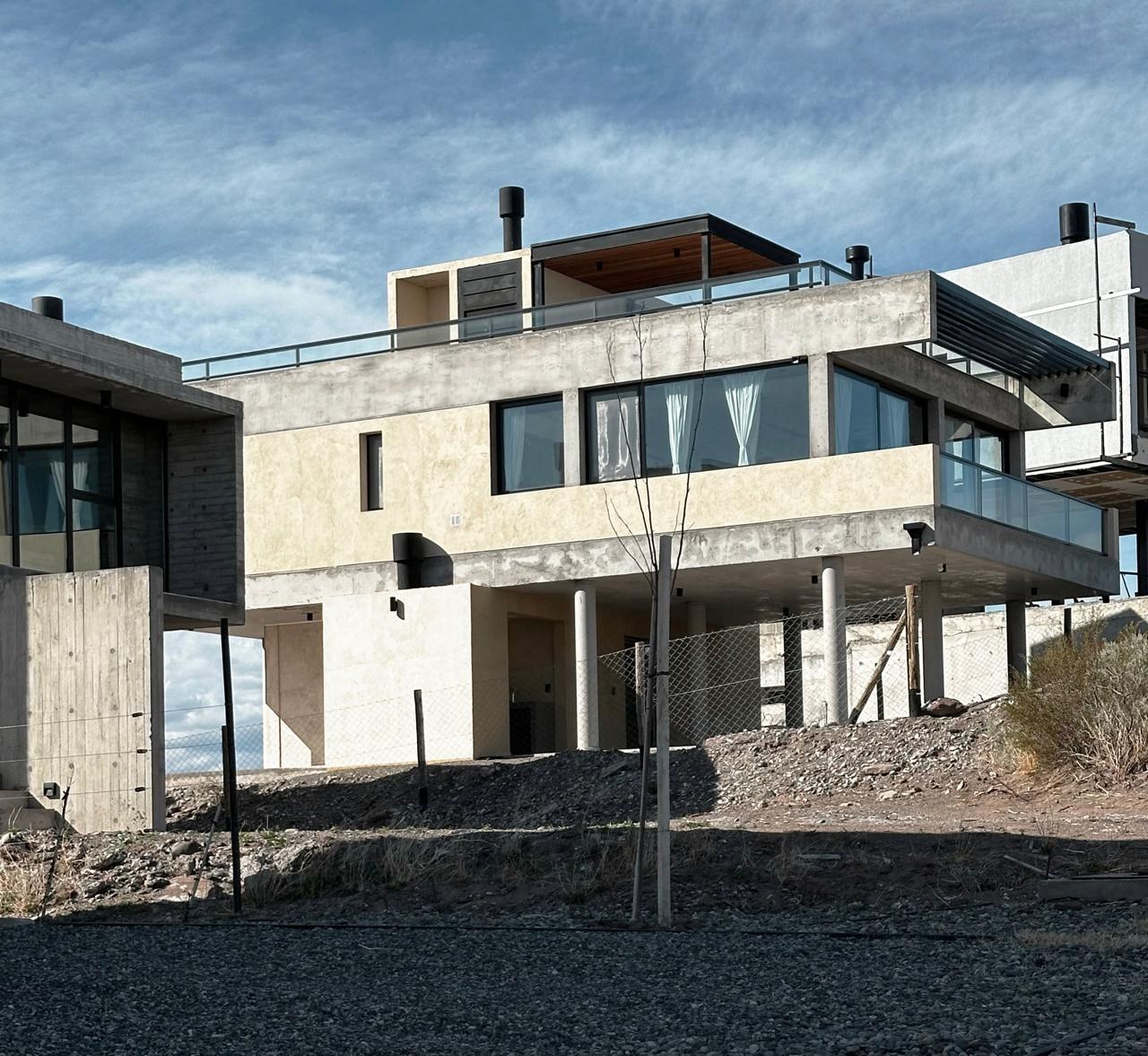 Casa Chocón Medio, vivienda de PROA en Villa El Chocón: fotografía de la casa terminada sobre sus pilotes