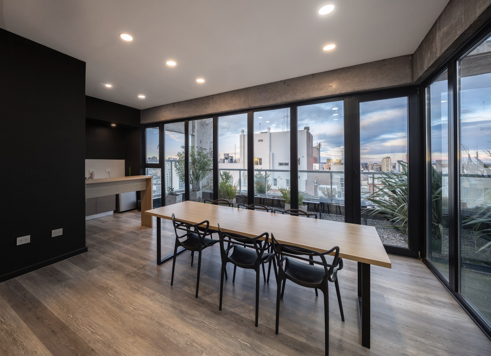 Salón con piso de madera y ventanales hacia la ciudad, fotografía de obra